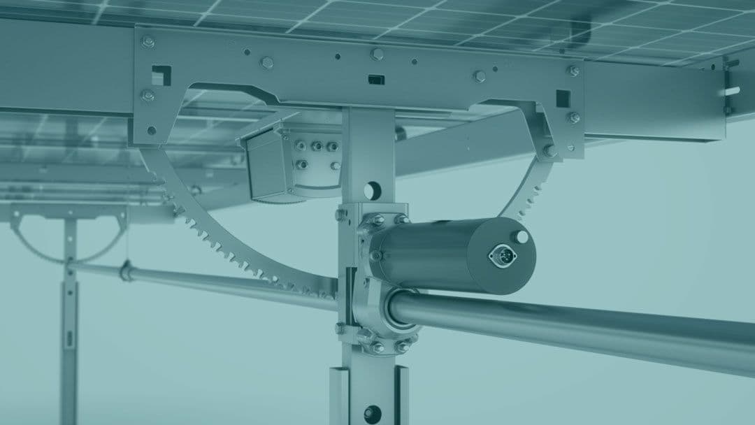 Close-up view of solar panel mounting hardware, showing gears and a motorized mechanism, part of a solar tracking system.